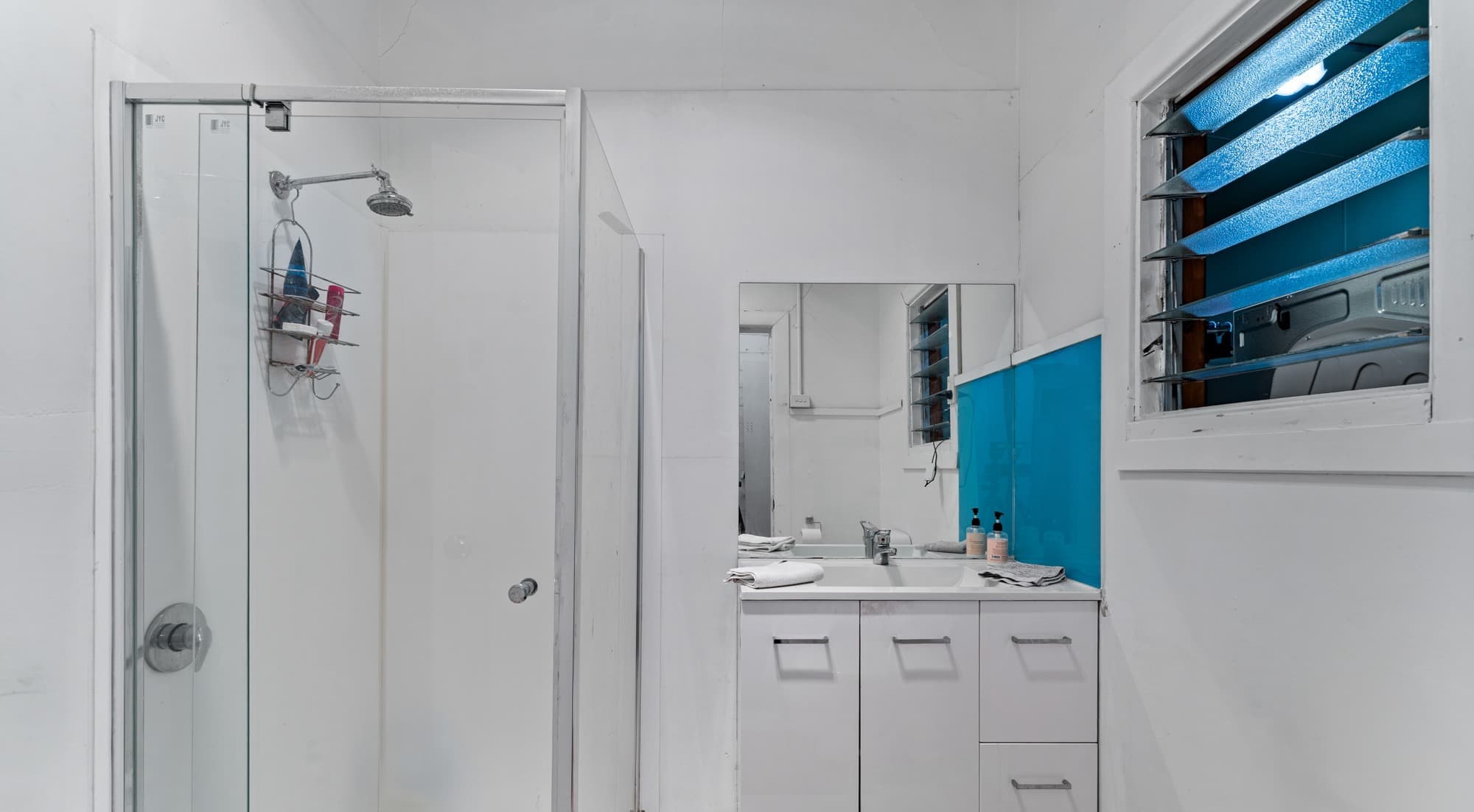 209 Ballarat Road bathroom - white vanity, shower screen and teal louvre window detail