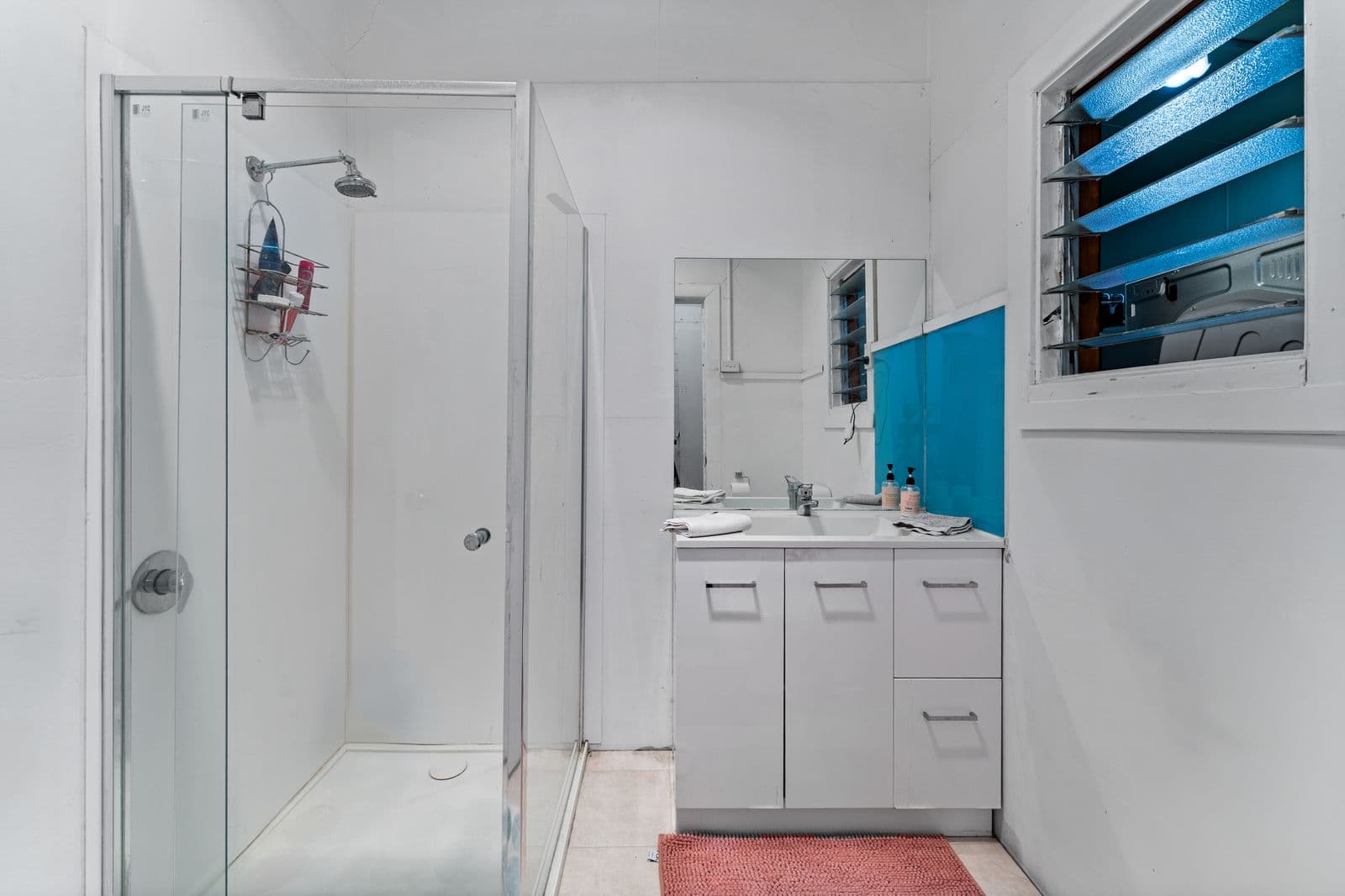 Ballarat Road bathroom - white vanity, shower screen and teal louvre window detail