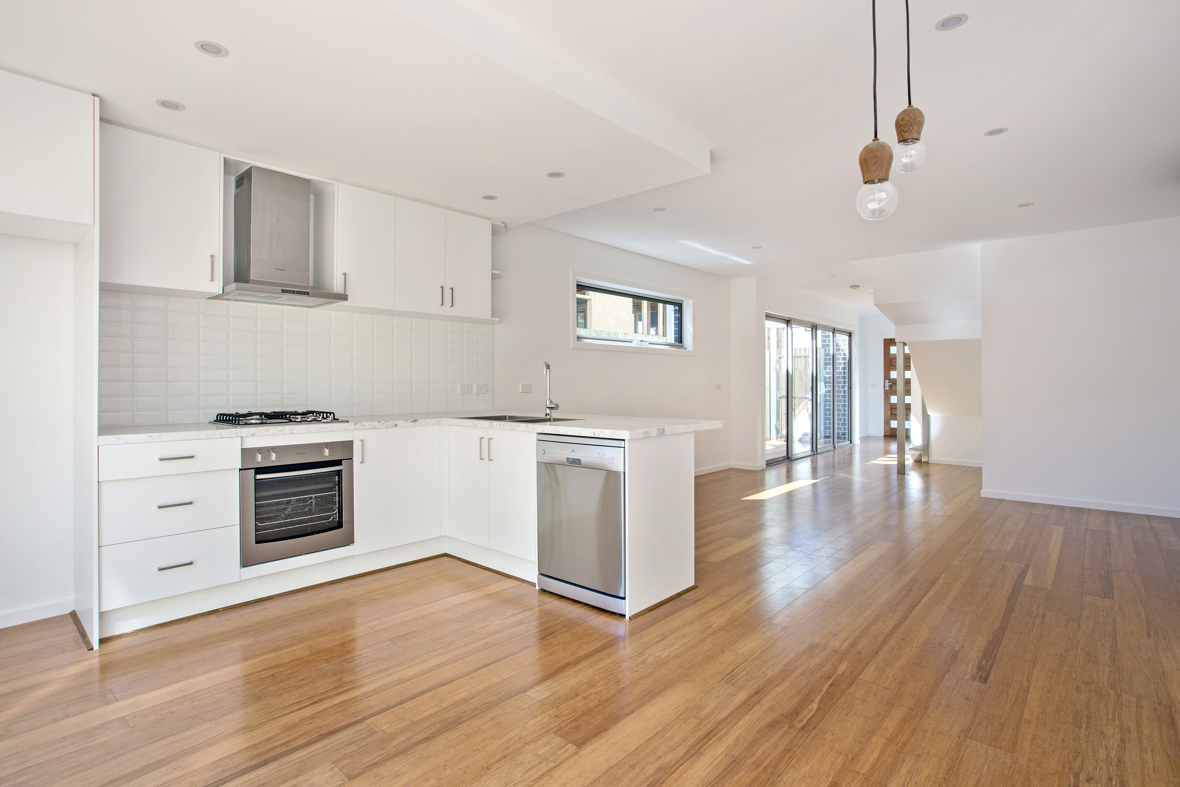 Chatham Street open-plan living and kitchen - white cabinetry, bamboo floors and full appliances