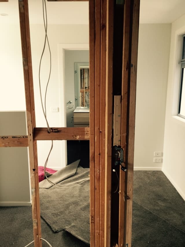 Foreman Way room extension - timber door frame opening punched through into the existing house, bathroom visible beyond