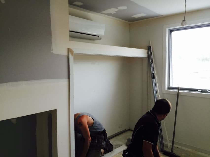 Two tradespeople fitting the built-in wardrobe in the new Foreman Way room