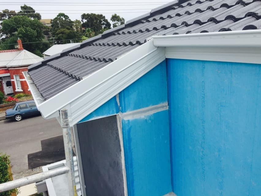 Foreman Way extension exterior - new terracotta roof tiles being laid with Anticon wrap cladding and white gutters