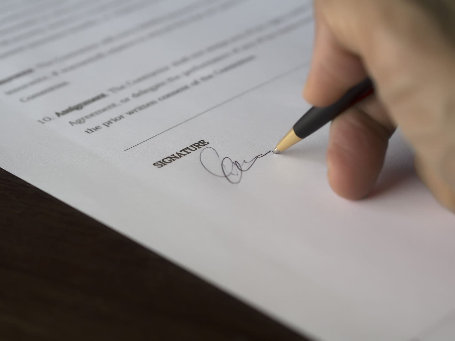 Close-up of a hand signing a building contract
