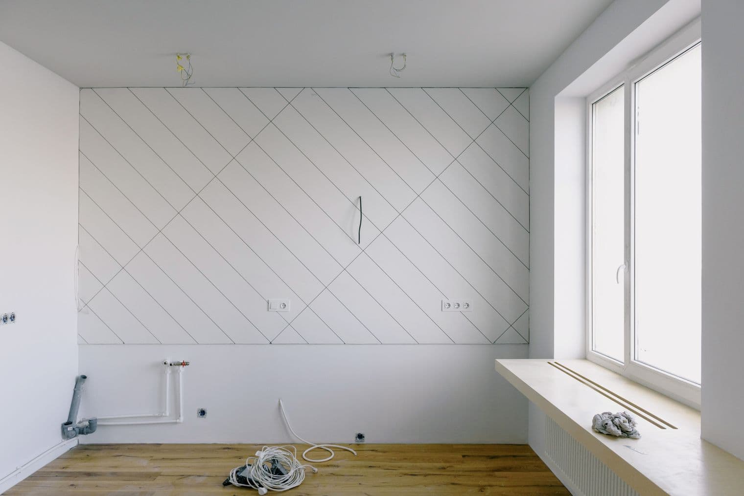 Room mid fit-out with capped plumbing stub-outs, electrical rough-in and a large window