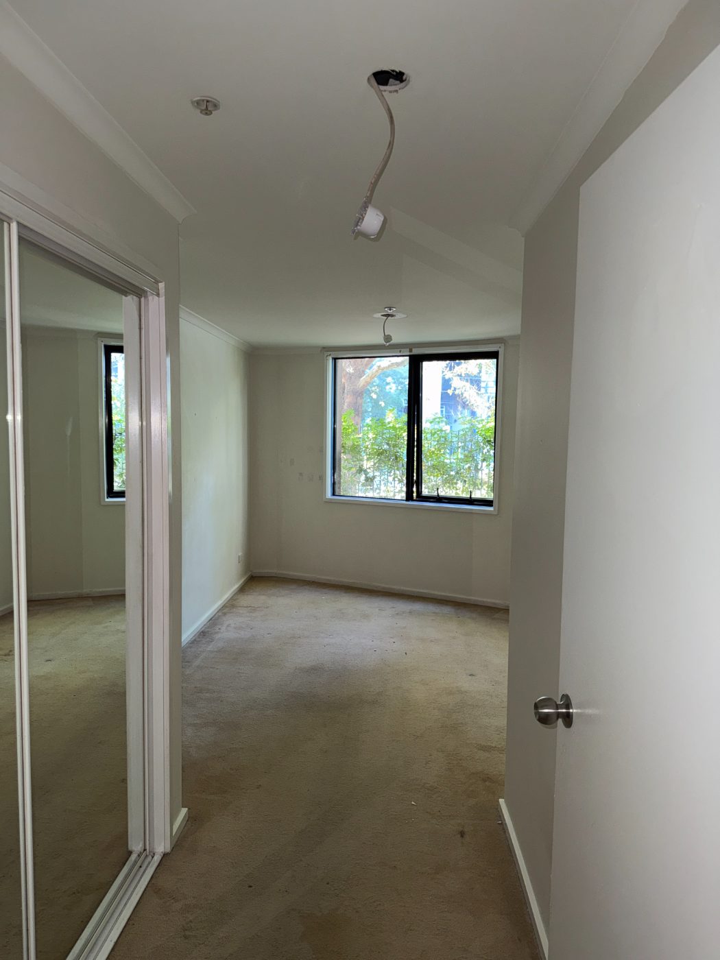 Master bedroom before renovation - stained carpet and worn paint